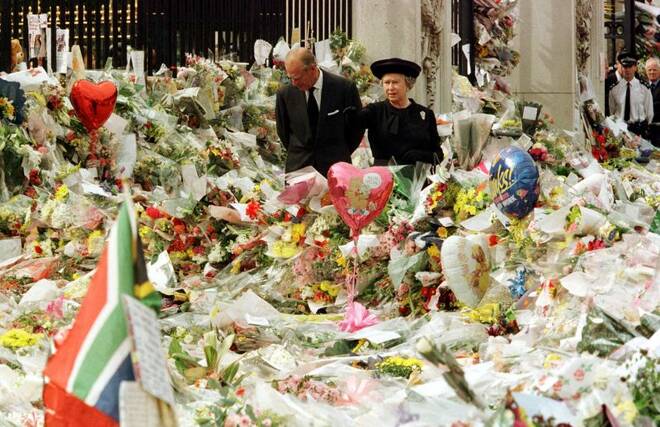 Queen Elizabeth II and Duke of Edinburgh look at the mass of floral tributes laid outside Buckingha..