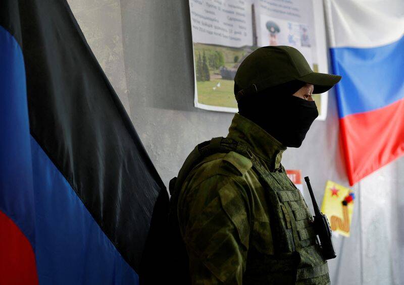 A service member of the self-proclaimed Donetsk People's Republic stands guard at a polling station ahead of the planned referendum in Donetsk