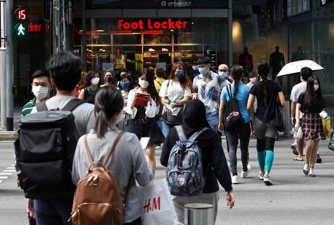 Shoppers wearing protective face masks cross a street in Singapore's Orchard Road shopping district during the coronavirus disease (COVID-19) outbreak