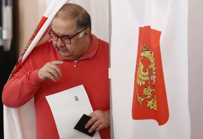 Russian billionaire Usmanov walks out of a voting booth at a polling station during the presidential election in Moscow