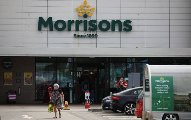 A customer carries a shopping bag outside a Morrisons supermarket in New Brighton