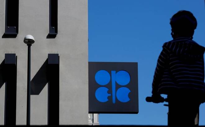 A person passes the OPEC logo in front of its headquarters in Vienna