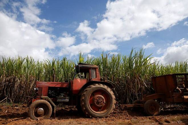 A tractor sits near a sugar cane field while people wait for the caravan carrying Cuba's late President Fidel Castro's ashes in Florida, Cuba