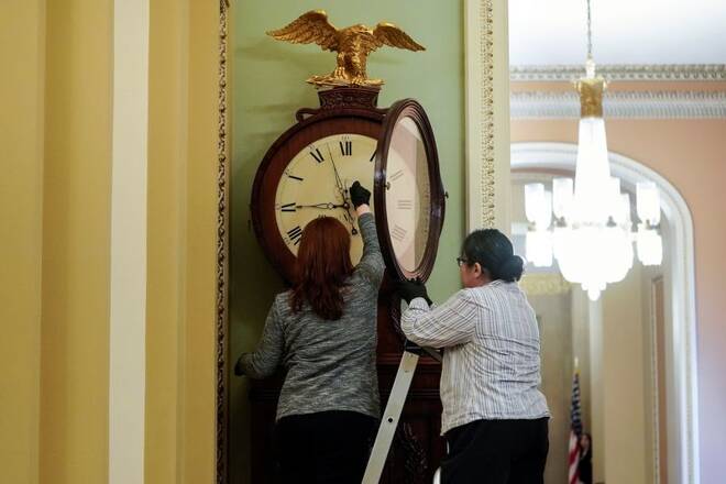 Architect of the Capitol workers wind the Ohio Clock on first day of Trump impeachment in Washington.