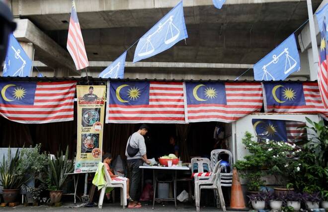Barisan Nasional flags and Malaysia flags hang at a food stall during the campaign period of Malaysia's general election in Kuala Lumpur