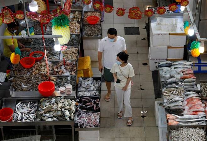 People shop for fish at a wet market during the coronavirus disease (COVID-19) outbreak, in Singapore