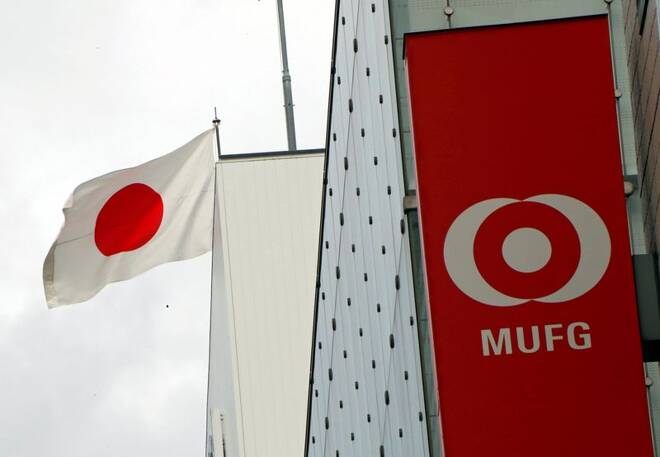Japan's national flag is seen behind the logo of Mitsubishi UFJ Financial Group Inc (MUFG) at its bank branch in Tokyo