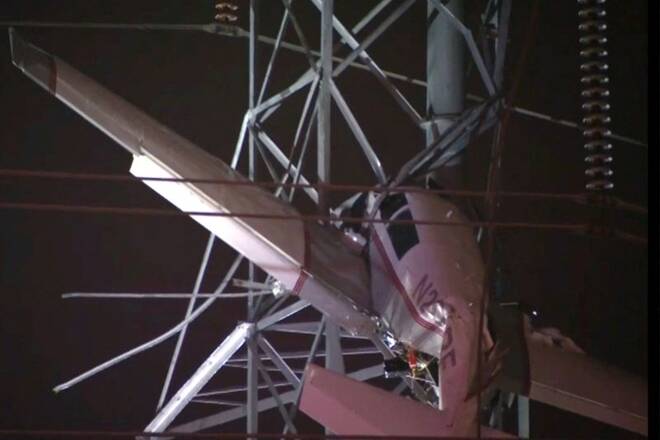 A small airplane hangs about 100 feet above the ground after crashing into an electricity tower in Gaithersburg