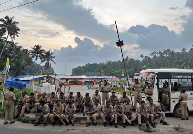 Police officers are deployed as fishermen protest near the entrance of the proposed Vizhinjam Port