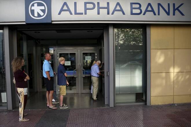 People line up at an ATM outside an Alpha Bank branch in Athens