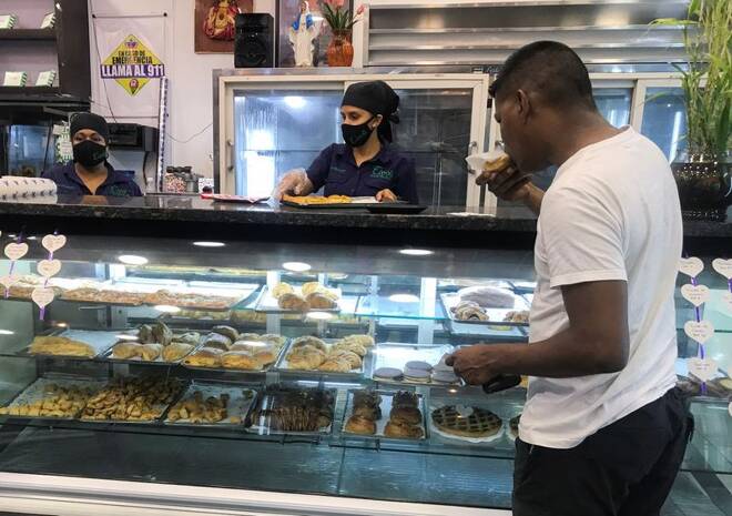 A customer eats a pastry at a bakery, in Caracas