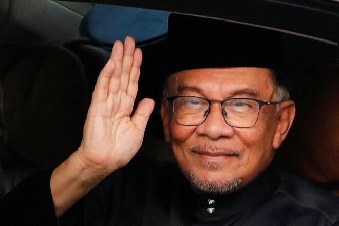 Malaysian new Prime Minister Anwar Ibrahim waves at the photographer as he arrives at the National Palace in Kuala Lumpur
