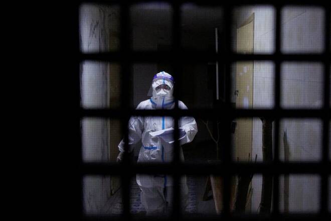 A pandemic prevention worker in a protective suit approaches an apartment in a building that went into lockdown as coronavirus disease (COVID-19) outbreaks continue in Beijing