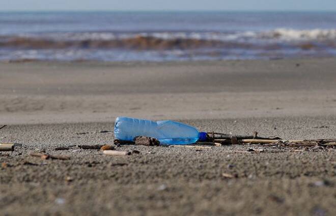 A plastic bottle lies on the sand at Maccarese beach in Italy