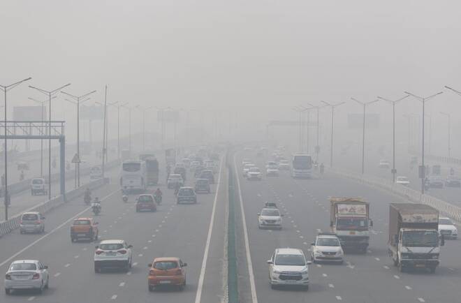 Traffic moves along a highway shrouded in heavy smog in New Delhi