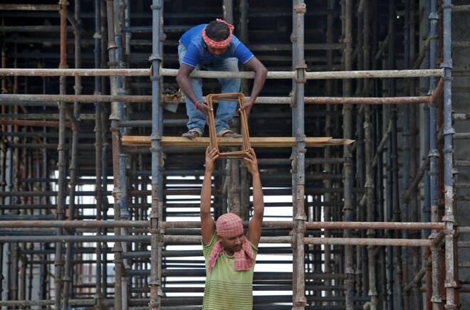Labourers work at the construction site of a residential building on the outskirts of Kolkata