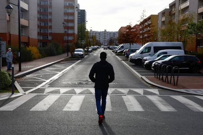A man walks on a street near residential apartment buildings in Epinay-sous-Senart near Paris