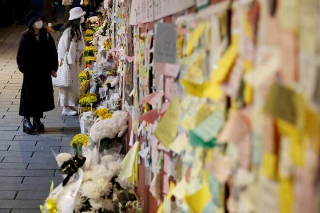 Women mourn at the scene of a crowd crush that happened during Halloween festivities in Seoul