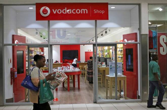 A shopper walks past a Vodacom shop in Johannesburg