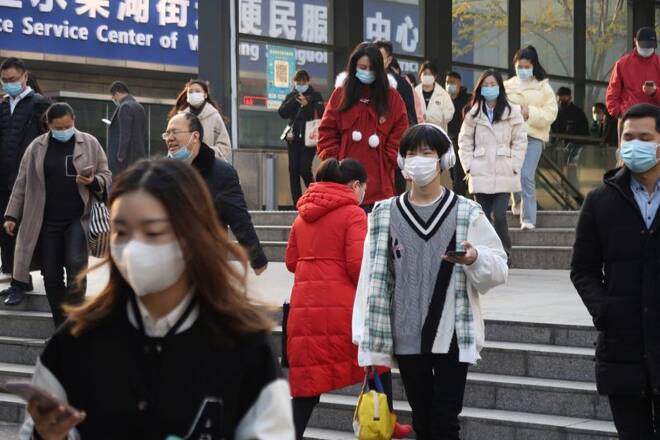 People walk out of a subway station during morning rush hour in Wuchang district, after the government gradually loosened restrictions on COVID-19 control, in Wuhan, Hubei