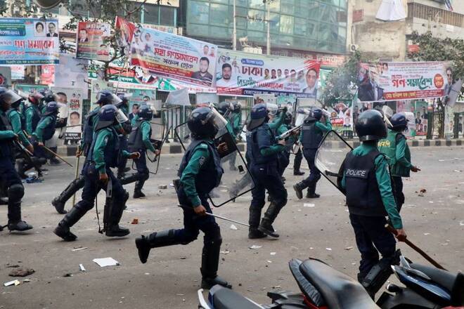 Bangladeshi policemen run to disperse Bangladesh Nationalist Party (BNP) activists gathered in front of the party's central office before clash in Dhaka