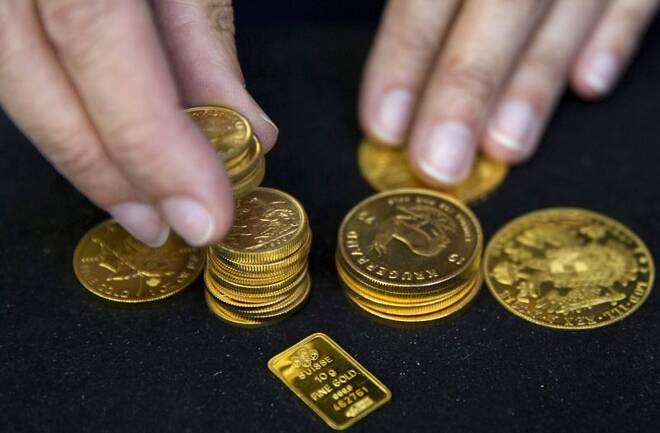 A worker places gold bullion on display at Hatton Garden Metals precious metal dealers in London