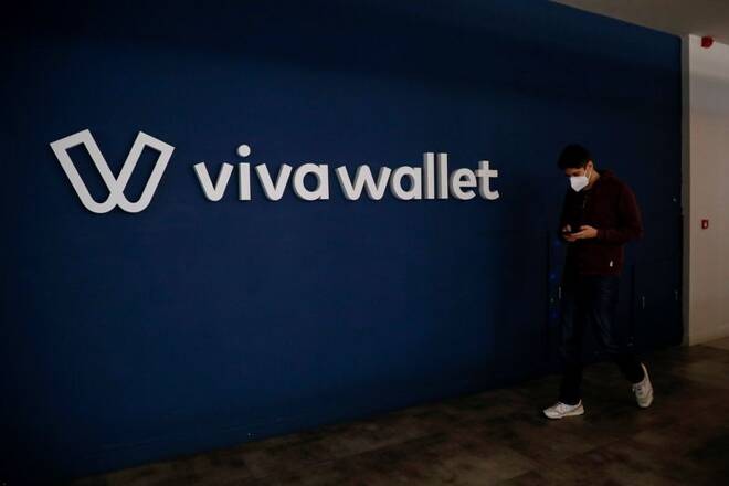 An employee walks past the Viva Wallet logo at the headquarters of the company in Athens