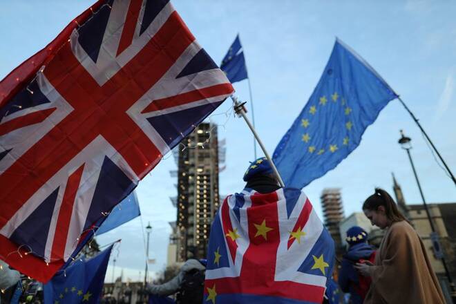 A man is seen holding EU and Britain flag outside the Houses of Parliament in London