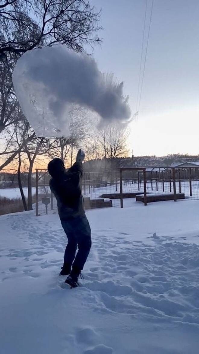 A man tosses hot boiling water in the snow in Carbon County, Montana