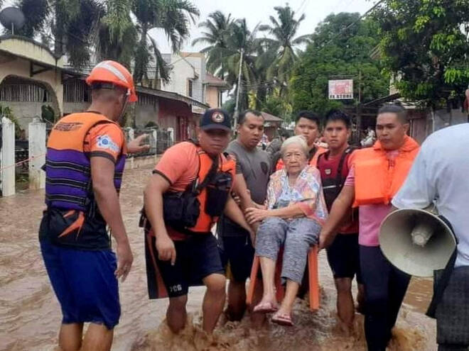 Rescue workers helps people affected by floods in Philippines