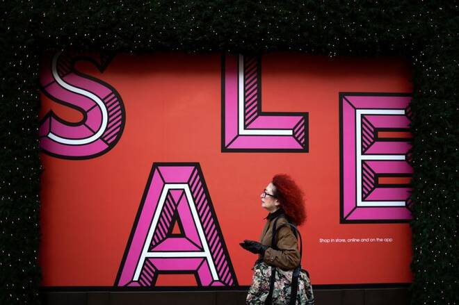 A person walks past sale signage on Oxford Street during the second day of Boxing Day sales, in London