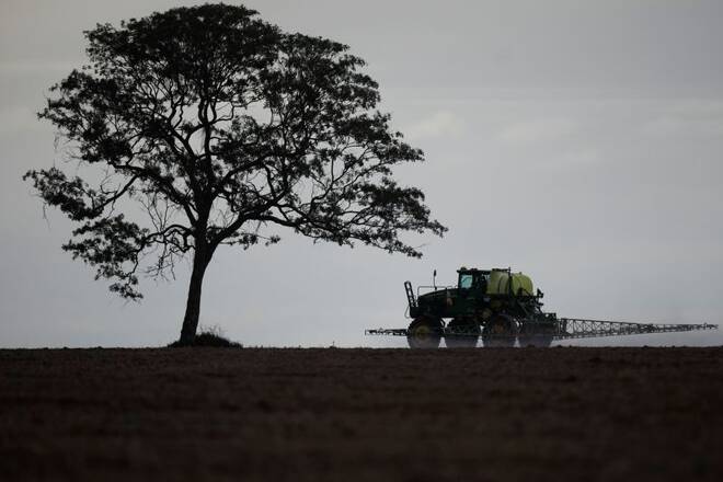 A tractor sprays herbicide in a soybean field, near Brasilia