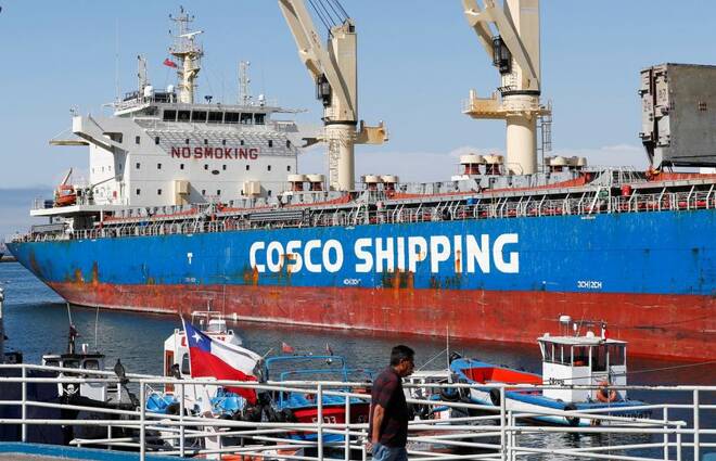 A man walks near a China Ocean Shipping Company (COSCO) container ship at the Valparaiso port