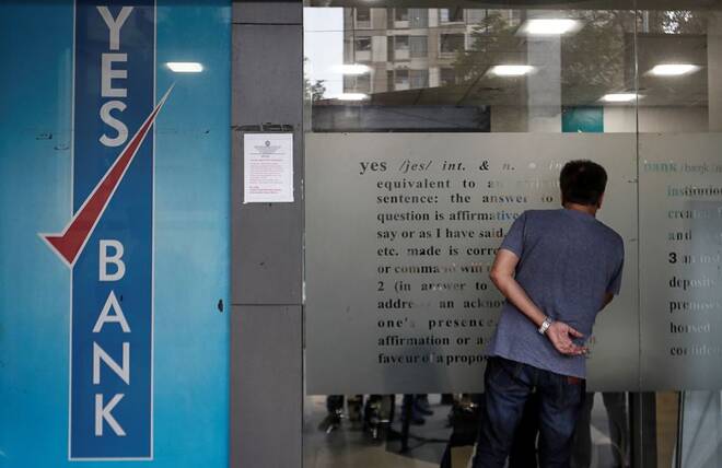 A customer tries to look into a Yes Bank branch in Mumbai