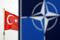 A Turkish flag flies next to NATO logo at the Alliance headquarters in Brussels