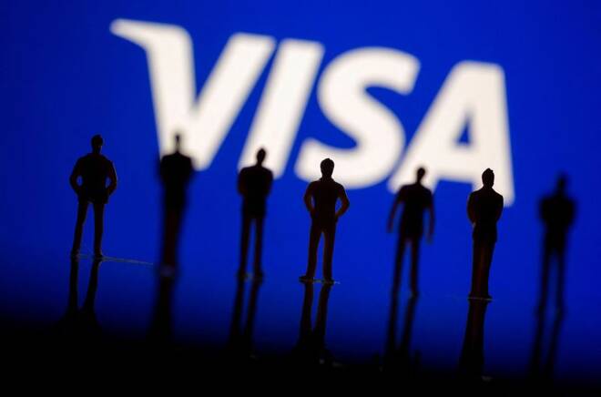 Small toy figures are seen in front of displayed Visa logo in this illustration taken