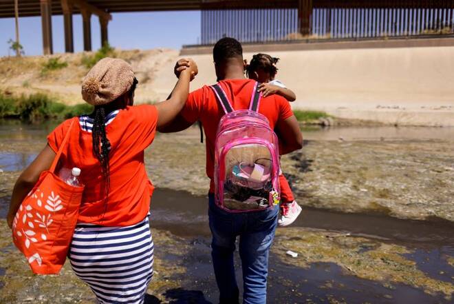 Asylum-seeking migrants cross the Rio Bravo river in El Paso