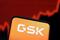 Illustration shows GSK (GlaxoSmithKline) logo and rising stock graph