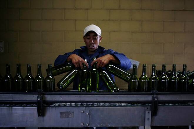 A worker loads wine bottles onto a conveyer belt at the Rostberg bottling plant near Cape Town