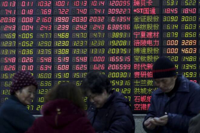 Investors stand in front of an electronic board showing stock information on the first trading day after the week-long Lunar New Year holiday at a brokerage house in Shanghai