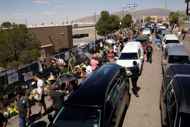 People gather during a tribute to the victims of a mass shooting at a Walmart store, in the growing memorial in El Paso