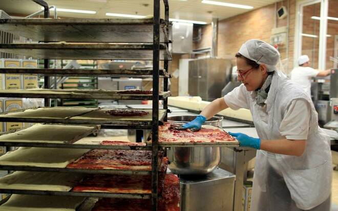 An employee prepares pizzas at the Panomara supermarket in Parma