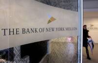 A woman walks past a logo at the office of the Bank of New York Mellon in Brussels