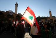 Protesters carry flags near the entrance leading to parliament building in Beirut
