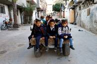 Gaza man offers to some students a low-cost donkey-cart ride to school in Khan Younis