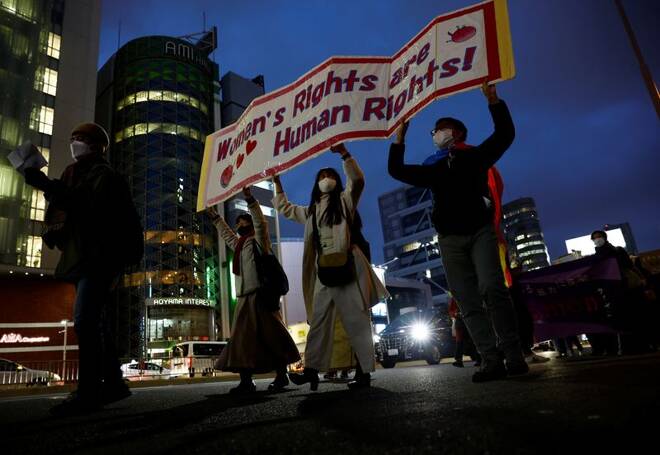 Participants hold a placard at a march to call for gender equality and protest against gender discrimination on International Women's Day in Tokyo