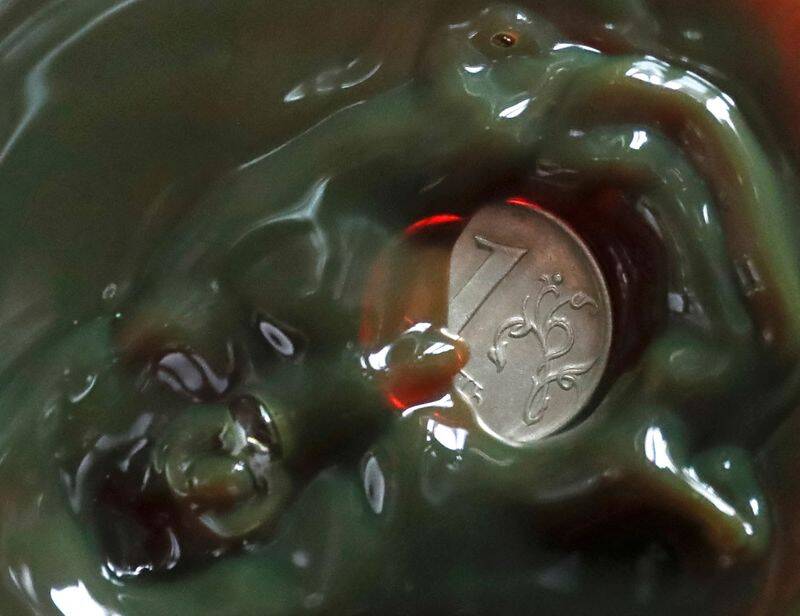 A view shows a one Russian rouble coin inside a bulb with crude oil at a laboratory in the Irkutsk Oil Company-owned Yarakta Oil Field in Irkutsk Region