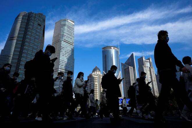 People cross a street near office towers in the Lujiazui financial district, ahead of the National People's Congress (NPC), in Shanghai