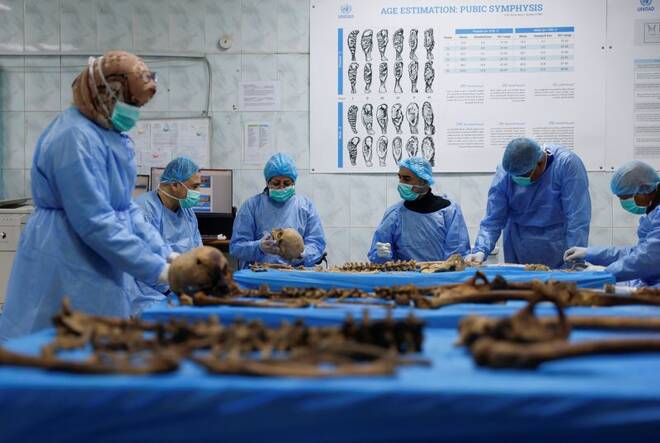 A team works to identify remains exhumed from a mass grave in the medico-legal directorate of Iraq's ministry of health, in Baghdad