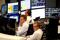 Share traders look at their screens in Frankfurt